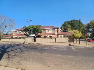 a house on the corner of a street with a fence at Wonder House Lodge in Mokopane
