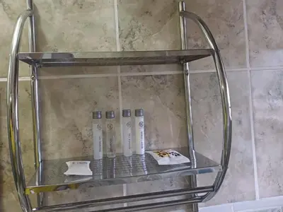 a glass shelf in a shower with bottles on it at Wonder House Lodge in Mokopane