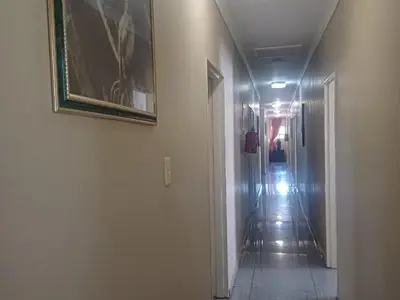 a hallway with a painting on the wall and a hallwayngthngthngthngthngth at Wonder House Lodge in Mokopane