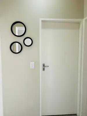 a white door with a mirror on the wall at Stunning modern 2 bedroom apartment in Waterfall Ridge in Midrand