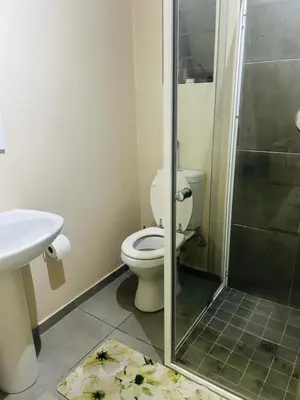 a bathroom with a toilet and a shower and a sink at Stunning modern 2 bedroom apartment in Waterfall Ridge in Midrand