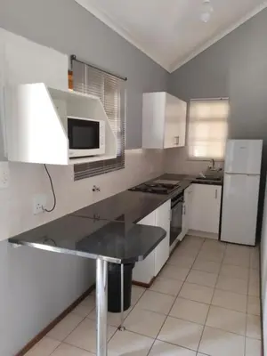 a kitchen with white cabinets and a black counter top at 77 Pendleberry Grove in Warmbaths