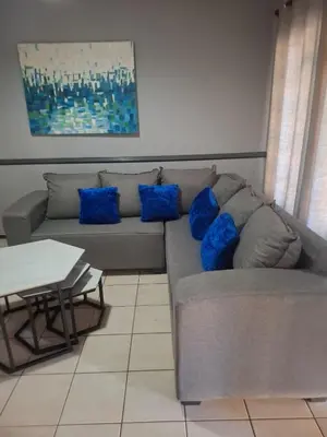 a couch with blue pillows in a living room at 77 Pendleberry Grove in Warmbaths