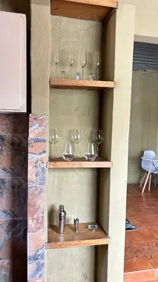 a shelf filled with wine glasses on a wall at Garden Unit in Pretoria
