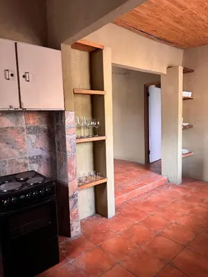 a kitchen with a stove and shelves in it at Garden Unit in Pretoria