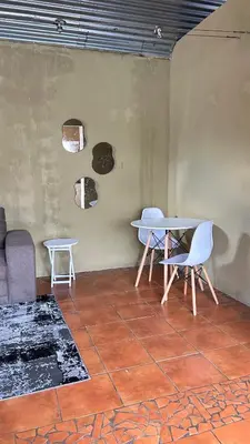 a room with a table and chairs and a couch at Garden Unit in Pretoria