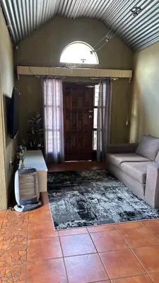 a living room with a couch and a tv at Garden Unit in Pretoria