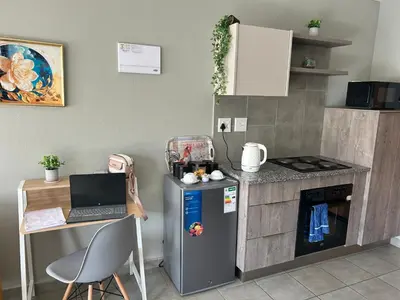 a kitchen with a desk and a laptop on a counter at Double Bed in the Capital City in Pretoria