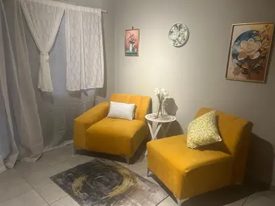a living room with two chairs and a table at Double Bed in the Capital City in Pretoria