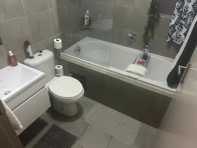 a bathroom with a toilet and a tub and a sink at Double Bed in the Capital City in Pretoria