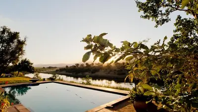 a swimming pool with a view of a river at River Retreat in Malelane