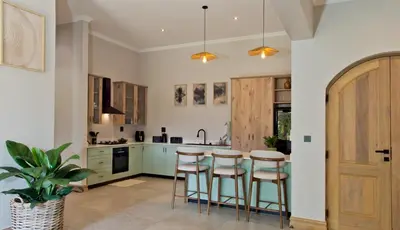 a kitchen with a table and stools in it at River Retreat in Malelane