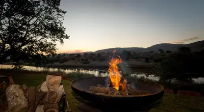a fire pit in a yard with the sunset in the background at River Retreat in Malelane