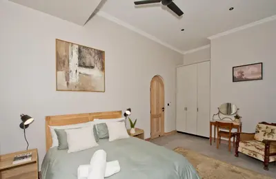 a bedroom with a bed and a chair at River Retreat in Malelane