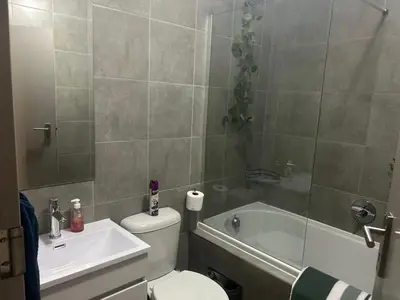 a bathroom with a toilet and a tub and a sink at Two Bedrooms in the Capital City in Pretoria