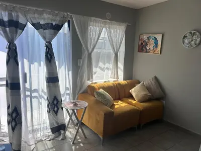 a living room with a couch and a window at Two Bedrooms in the Capital City in Pretoria