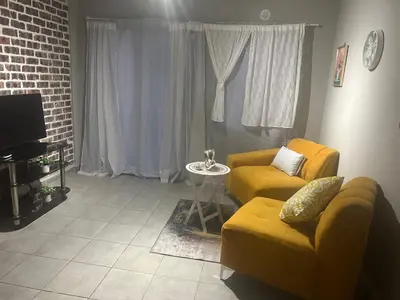 a living room with a couch and a table at Two Bedrooms in the Capital City in Pretoria