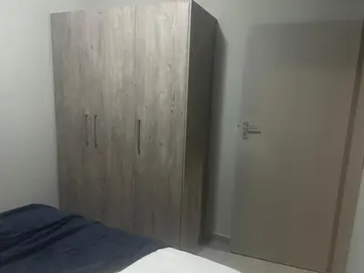 a bedroom with a wooden cabinet next to a bed at Two Bedrooms in the Capital City in Pretoria