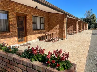 a brick building with benches and flowers in front of it at Pecan Stay Bed and Breakfast in Rayton