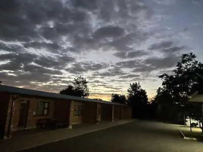 a cloudy sky above a building with a parking lot at Pecan Stay Bed and Breakfast in Rayton