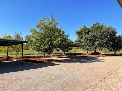 a parking lot with a canopy and some trees at Pecan Stay Bed and Breakfast in Rayton