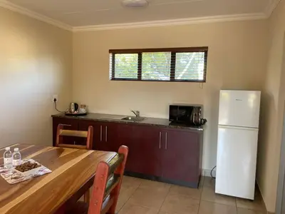 a kitchen with a table and a white refrigerator at Pecan Stay Bed and Breakfast in Rayton