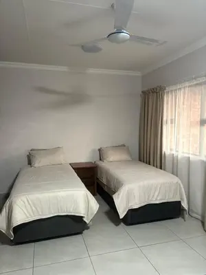 a bedroom with two beds and a ceiling fan at Pecan Stay Bed and Breakfast in Rayton