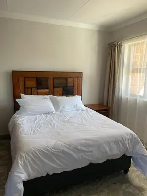 a bedroom with a bed with white sheets and a window at Pecan Stay Bed and Breakfast in Rayton