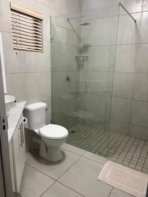 a bathroom with a toilet and a glass shower at Pecan Stay Bed and Breakfast in Rayton