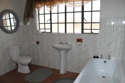 a bathroom with a sink and a toilet and a bath tub at Ndlovu 41 inside the Dinokeng Big 5 Game Reserve in Dinokeng Game Reserve