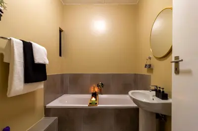 a bathroom with a bath tub and a sink at The Local house in Midrand