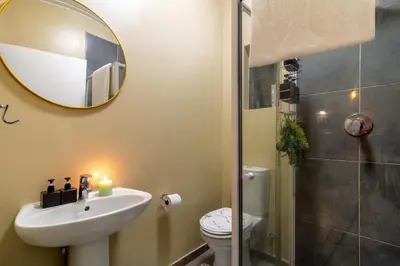 a bathroom with a sink and a toilet and a mirror at The Local house in Midrand