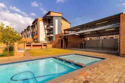 a large swimming pool in front of a building at The Local house in Midrand