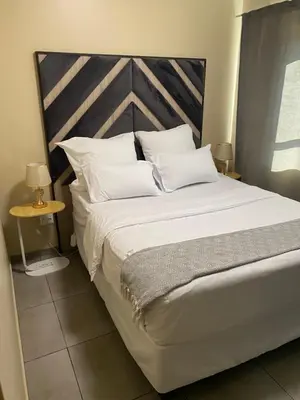 a bedroom with a large white bed with a wooden headboard at The Local house in Midrand