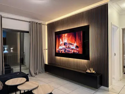 a living room with a fireplace with a tv at The Dream Stay At The Blyde - Suite 1 in Pretoria