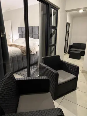 a bedroom with a bed and a chair and a mirror at The Dream Stay At The Blyde - Suite 1 in Pretoria