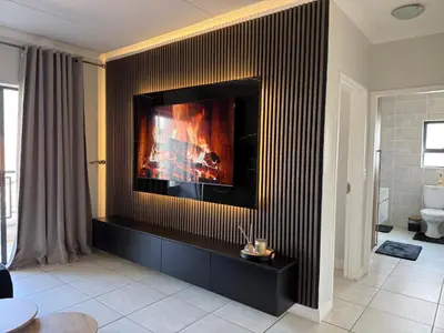 a living room with a fireplace on the wall at The Dream Stay At The Blyde - Suite 1 in Pretoria