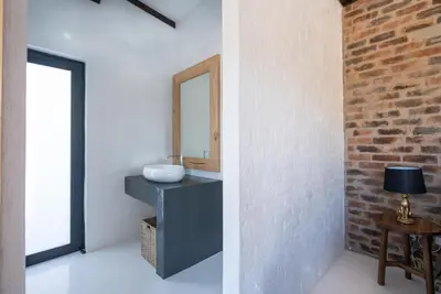 a bathroom with a sink and a brick wall at Thuhlo in Marloth Park