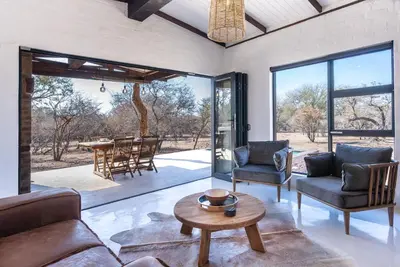 a living room with a couch and chairs and a table at Thuhlo in Marloth Park