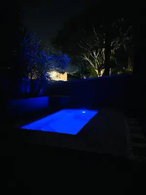 a swimming pool lit up in the dark at night at Grey Villa on Orion- Luxury Apartment in Polokwane