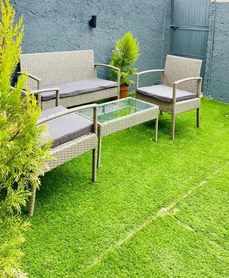 three chairs and a glass table in a yard at Grey Villa on Orion- Luxury Apartment in Polokwane