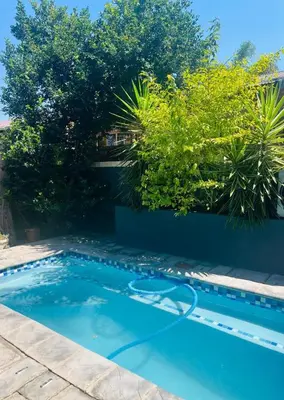 a swimming pool in a yard with a blue pool at Grey Villa on Orion- Luxury Apartment in Polokwane