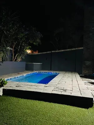 a swimming pool in a yard at night at Grey Villa on Orion- Luxury Apartment in Polokwane