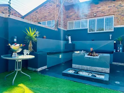 a room with a blue wall and a table at Grey Villa on Orion- Luxury Apartment in Polokwane