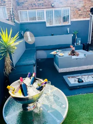 a living room with a table and a couch at Grey Villa on Orion- Luxury Apartment in Polokwane