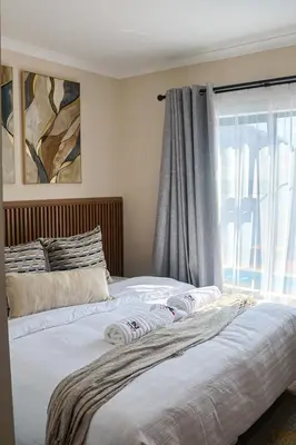 a bed in a bedroom with a window and a bedskirtspectspects at Kamotha Guest House