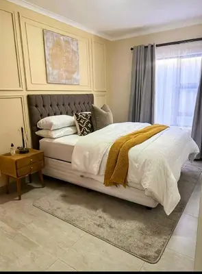 a bedroom with a large white bed with a window at Kamotha Guest House