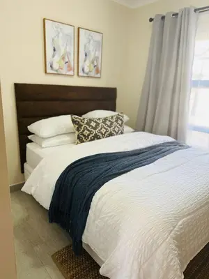 a bedroom with a large bed with pillows and a window at Kamotha Guest House