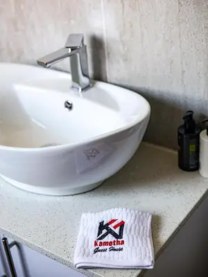a bathroom with a white sink on a counter at Kamotha Guest House
