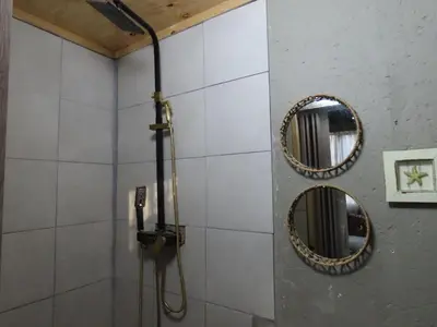 a bathroom with two mirrors and a shower at Unique Kruger Hide & Spa in Marloth Park